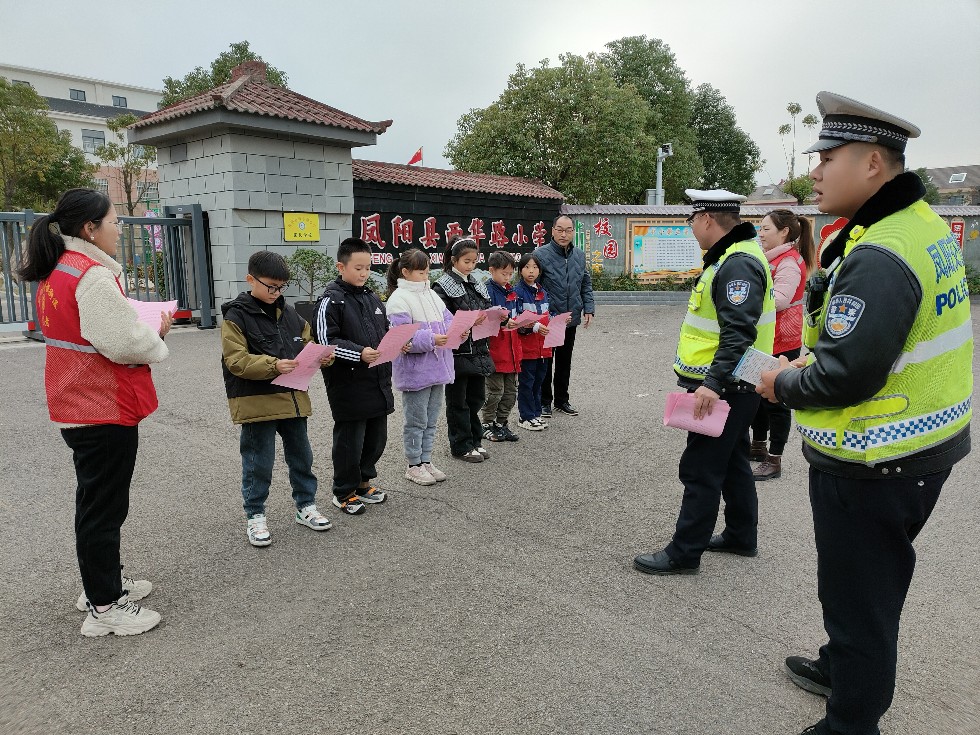 志愿者向学生发放宣传单、宣传手册等宣传资料与交警互动交流.jpg